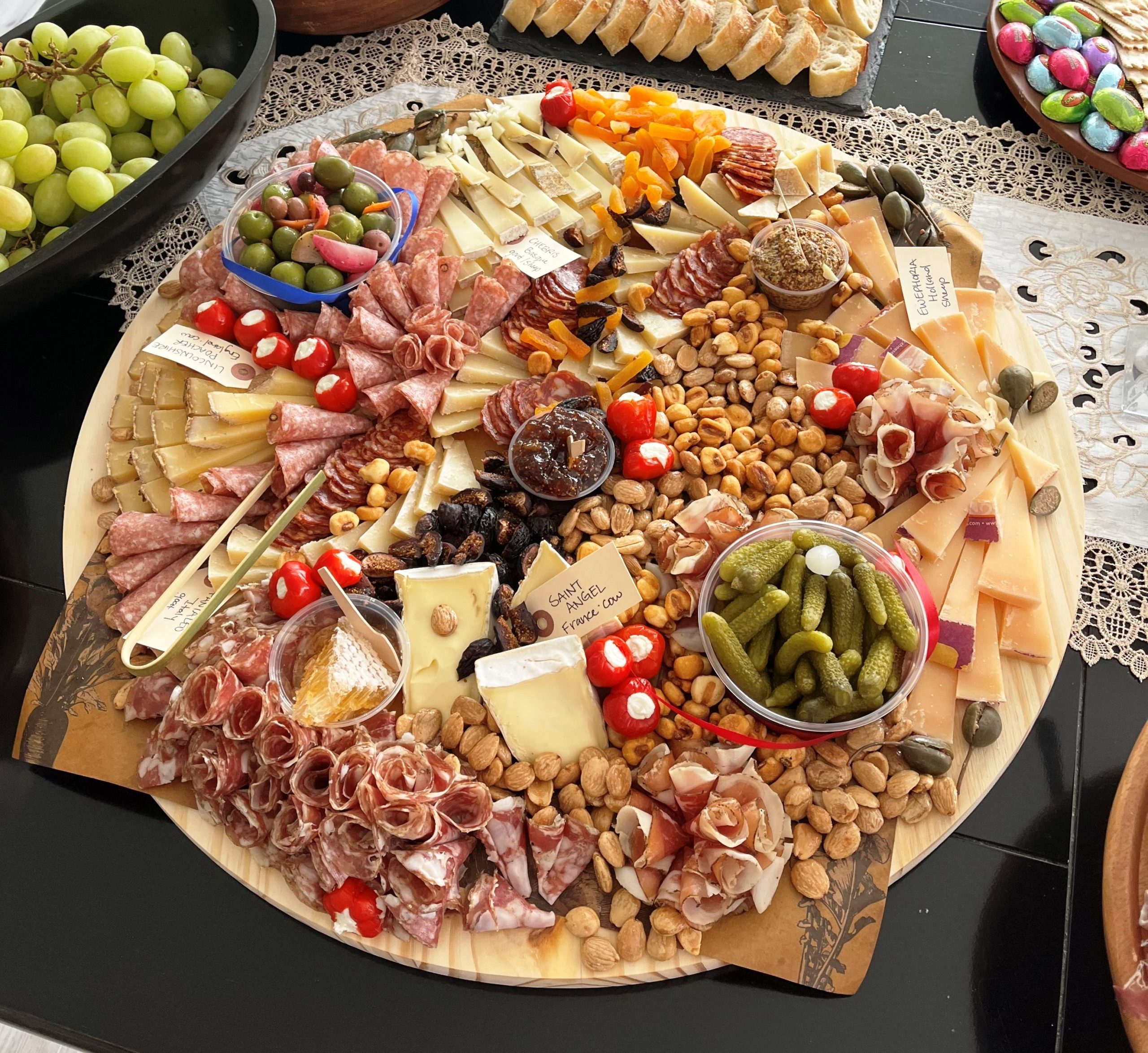 Photo of an extra-large gathering platter on a table with grapes and bread