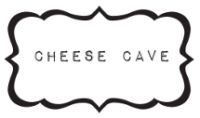 Scalloped logo which contains the words "Cheese Cave" in black and white.